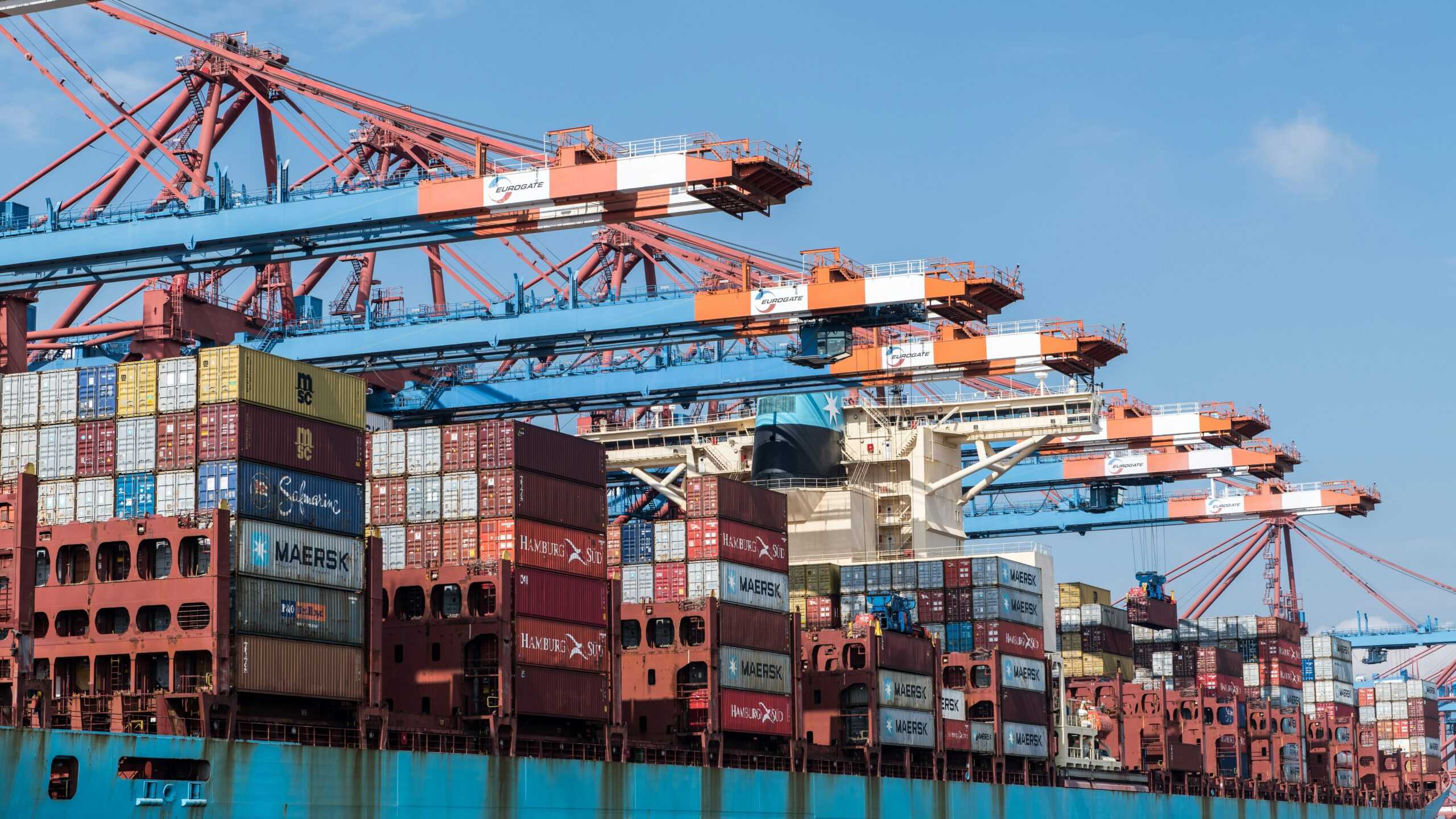 Image of colorful containers being stacked over each other at the port