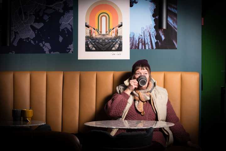 Wirepas mom drinking coffee on a brown couch